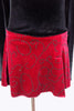 Black velvet skaters dress has long sleeves, high neck with red velvet band and keyhole back. Attached skirt is red with swirls of black beads. Comes with hair accessory. Skirt zoomed