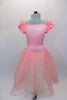 Romantic ballet tutu has layers of white tulle with peach overlay. The attached satin bodice has cream braiding along princess seam. Comes with floral hair accessory. Back