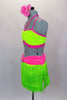 Neon green fringe skirt has pink gathered waistband with crystal buckle. Matching half-top has  pink leatherette banding and straps. Comes with hair accessory. Left side