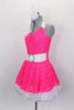 Neon pink dress has white spandex belt with crystal buckle. Has white ruffled underskirt for volume. Keyhole back attaches by a ring. Comes with hair accessory. Left side