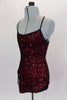 Classy red sequined tunic dress has black cross straps that dips into criss-cross  accent. The front comes to a point with center slit to create an elegant look. Comes with attached spandex briefs. Left side