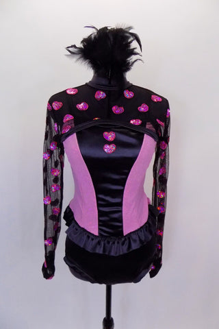 Three piece costume has pink & black corset top with pink hearts & bow at back. The sheer black shrug also has pink hearts. Comes with feather hair accessory. Front