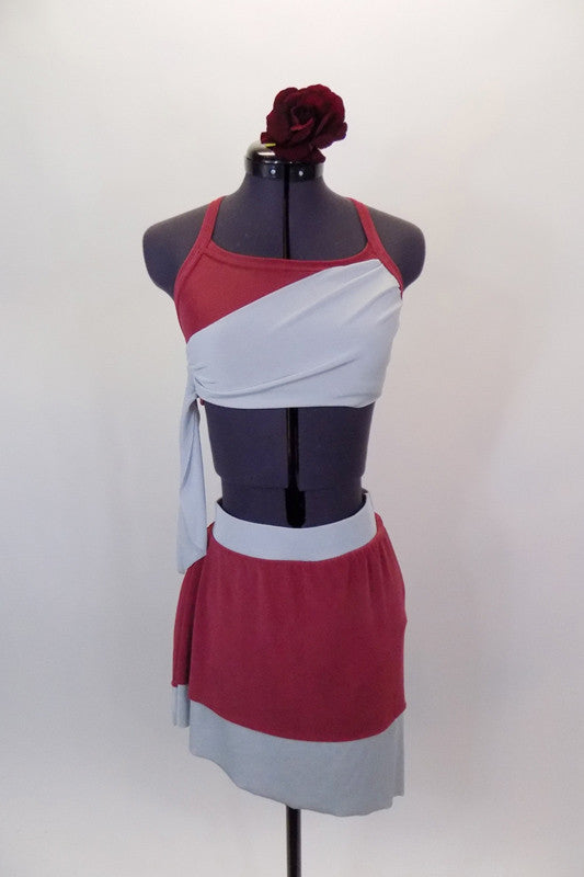 Deep rose and pale grey two-piece costume has halter neck bra with angled back straps. The matching knee length skirt is soft flowing stretch. Comes with matching  hair accessory. Front