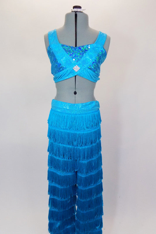 2-piece costume has layers of fringe covered pants in deepening shades of turquoise. Sequined half-top has bands that cross over the front with jewel accent. Comes with crystal hair barrette. Front