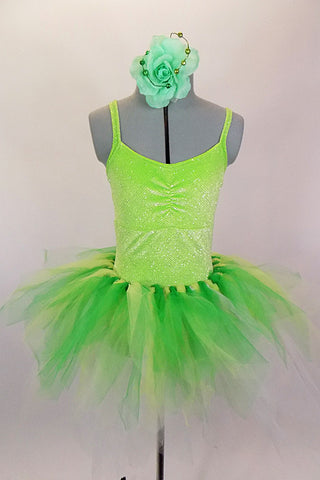 Green 2-piece costume is comprised of a neon green sparkle camisole leotard base. The pull on tutu is hand knotted strands of green yellow and white tulle. Comes with green floral hair accessory. Front