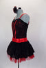 Black, sequined sheer bustier bodice with red stripe accents sits over red metallic bra, Attached black shorts have red waistband & tulle/mesh side bustle. Comes with matching hair accessory. Left side