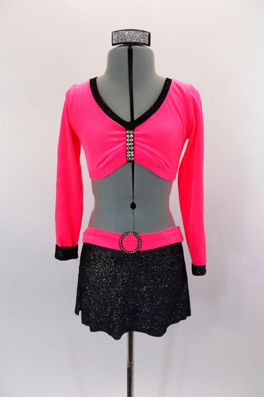 Neon pink velvet, long sleeved half top has crystalled pinch front. The black sparkle skirt has attached panty & pink velvet waistband with crystal buckle. Comes with hair accessory. Front
