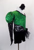 Green sequined asymmetrical one sleeve costume with pouf & lace. One side is cut-out with black lace. Black velvet shorts have sequined bow ruffle accent on hip. Comes with hair accessory. Right side