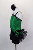 Green sequined asymmetrical one sleeve costume with pouf & lace. One side is cut-out with black lace. Black velvet shorts have sequined bow ruffle accent on hip. Comes with hair accessory. Left side