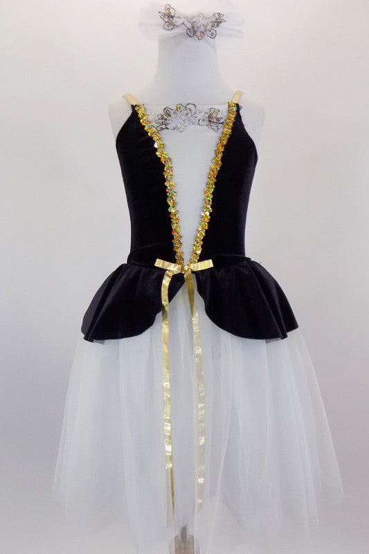 Black & white romantic tutu dress has skirt in layers of white tulle. The black velvet peplum bodice has white center panel with applique & gold braid accent. Comes with matching hair accessory. Front