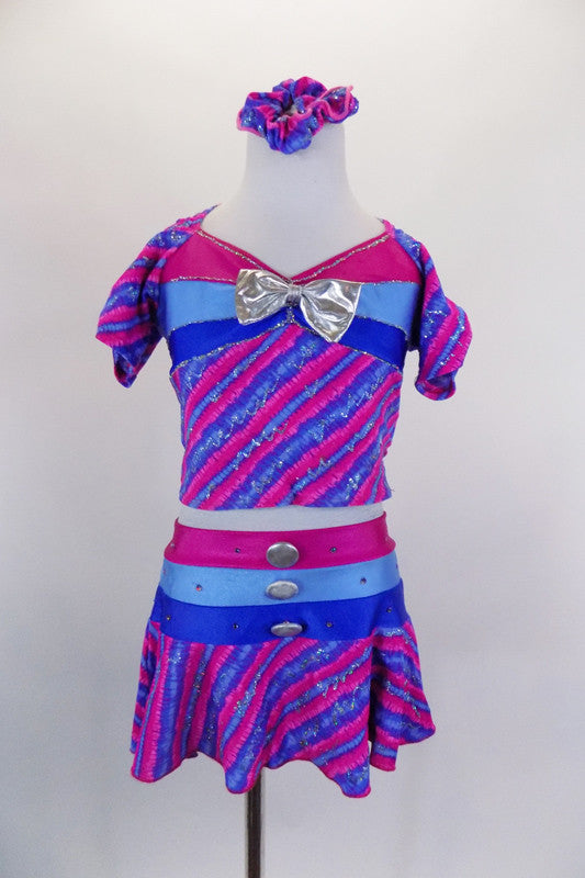 2-piece, purple-pink stripe costume with silver fleck, has pouf sleeve top. Bust and waist have bands of periwinkle-blue-pink, & silver bow. Has matching skort. Comes with matching hair scrunchie. Front