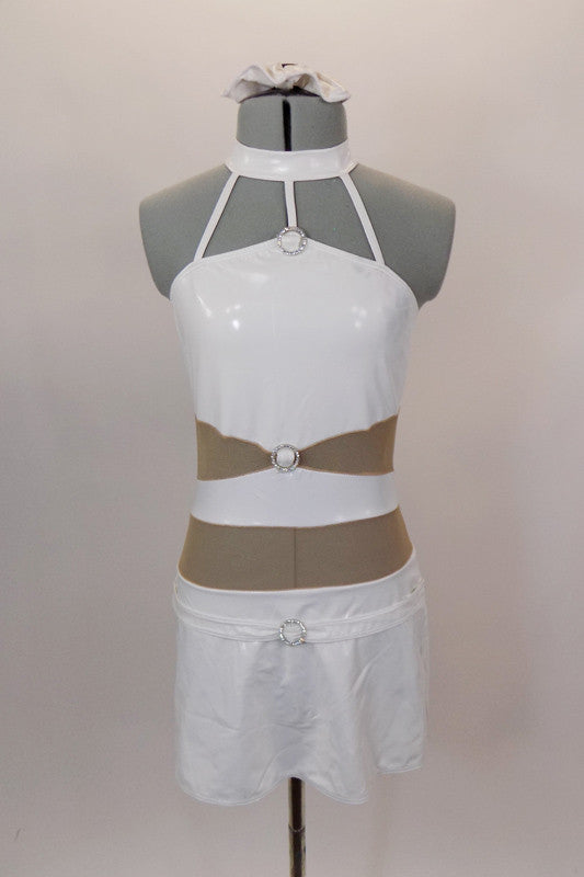 White faux leather halter leotard dress has attached skirt & choker collar with three straps that attach to the bodice. Nude sheer mesh exposes midriff. Has crystal ring accents & hair accessory. Front