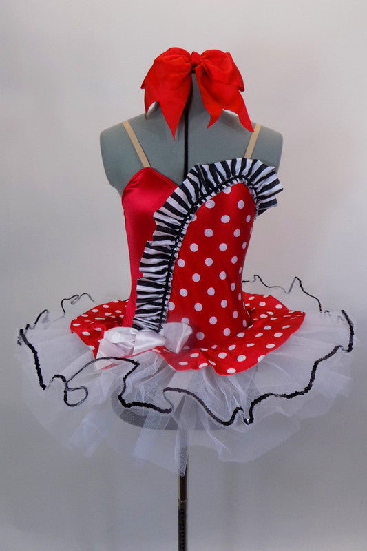 Red & white polka dot tutu dress has white tutu base with black sequin edge. Has black & white striped ruffle across sweetheart bodice. Comes with hair bow. Front