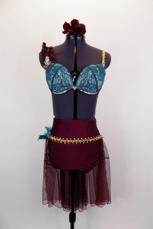 Teal (padded) lace bra, has gold braiding, Swarovski crystals, feathers, & jewel accent. The accompanying maroon bottom has gold braiding & long bustle skirt. Front