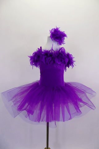 Purple velvet camisole tutu dress has layers of wide pleated organza skirt. The bust is lined with thick purple boa feathers. Comes with feather hair accessory. Front