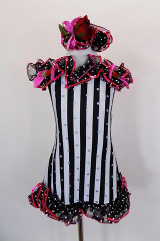 Black and white tunic dress has adjustable nude straps & silver sequin detail The edge has black and white polka dot organza ruffles with sequined edge. Comes with matching hair accessory. Front