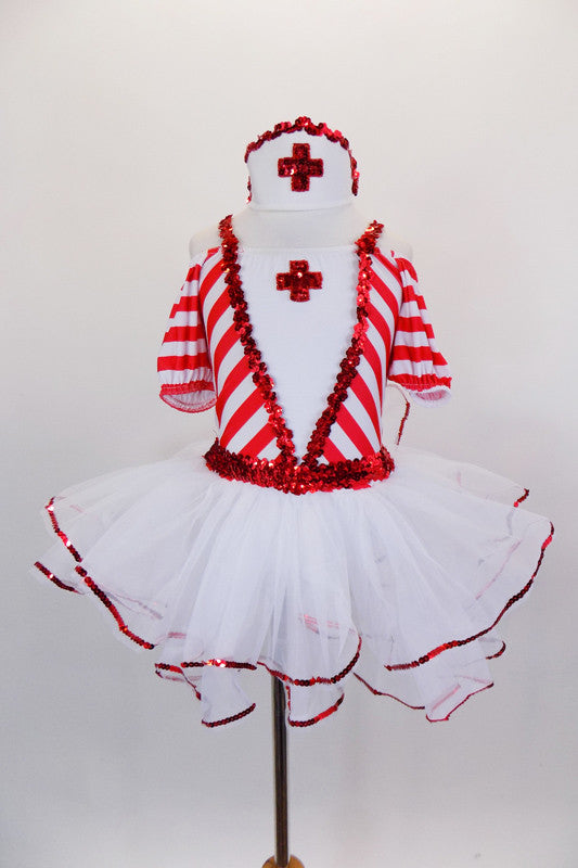 Red & white striped dress has pouf sleeves & white center edged in red sequin with large red cross applique. The attached skirt has petticoat with sequin edge. Comes with nurse hat accessory and ruffled socks. Front