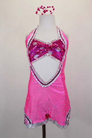 Pink short-tard has deep font plunge, open back & sequined silver ruffles, covered extensively with Swarovski crystals. Has attached hot pink polka dot bandeau bra and hair accessory. Front