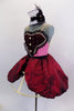 Pink camisole leotard has maroon, pearled bib front panel. Matching maroon, crinkle taffeta skirt is attached to cage crinoline. Has white & black lace choker. Comes with pink hair bow, sateen booties and arm bands.  Left side