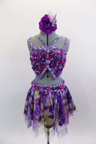 Beautiful purple fully sequined bra top has large floral paillette sequins & double straps. The matching skirt has purple base & sheer overlay of purple-grey-yellow patches. Comes with matching hair accessory. Front