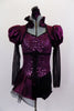 Corset style costume has purple sateen and black mesh pouf sleeves. Neckline is a Queen Anne style with ruffled neck & keyhole back. Has attached side bustle. Front