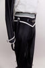 Black & white 2-piece costume has black pants with tie string at bottom & hanging suspenders with silver buttons. Jacket has mandarin collar & silver buttons. Side close-up of pants