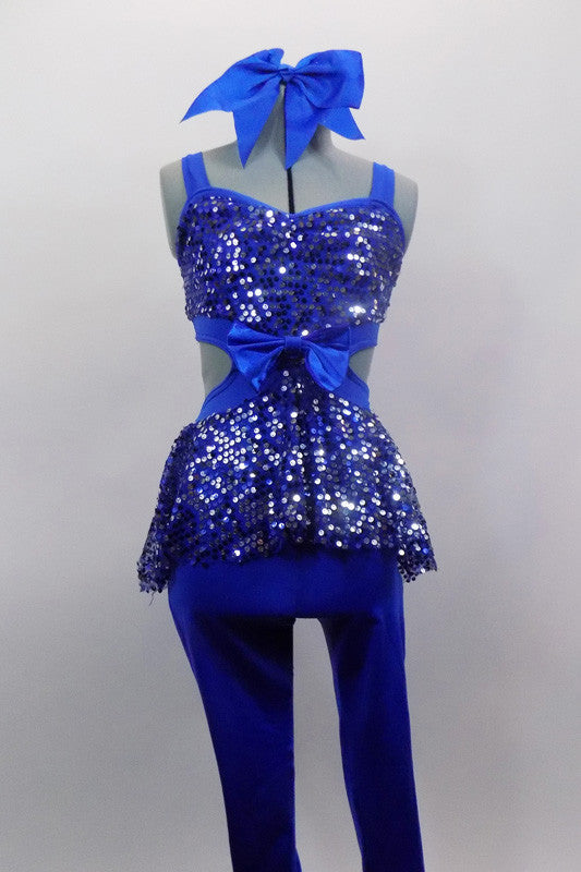 Royal blue unitard has fully sequined bodice with open back, sides & sequin peplum skirt. Has blue bow accent at the of torso & blue legging bottoms. Comes with large hair bow. Front