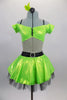 Lime green dress has nude torso with attached green bra top that has cap sleeves. Back has triple black straps joined by crystal ring. Skirt had black petticoat & crystal accents. Comes with hair accessory. Front