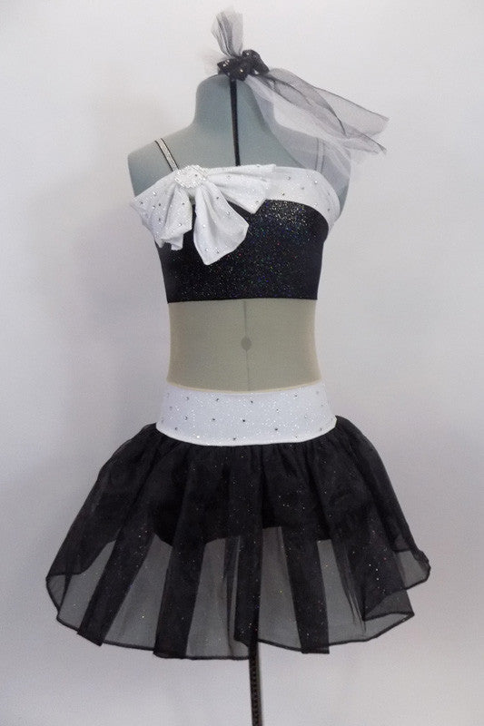 Black & white glitter dress has nude sheer center to create appearance of a 2- piece. Bust & waist have white band covered in crystals & large bow at right bust. Front