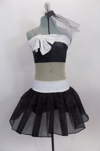 Black & white glitter dress has nude sheer center to create appearance of a 2- piece. Bust & waist have white band covered in crystals & large bow at right bust. Front
