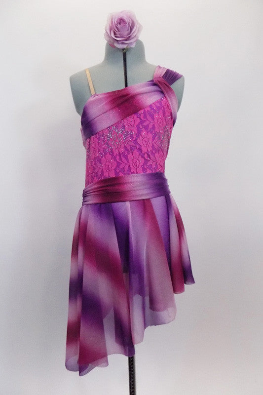 Asymmetrical dress in hues of pink and purple has striped sheer shawl accent collar that crosses at left shoulder on top of a pink lace bodice. The matching striped asymmetrical skirt has cummerbund waist. Comes with mauve rose hair accessory. Front