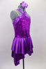 Purple sequined bodice is accented by wide satin banding that crosses over across the chest. The attached satin skirt i falls over the hips and is longer at the two sides. Comes with floral hair accessory. Side