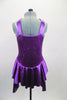 Purple sequined bodice is accented by wide satin banding that crosses over across the chest. The attached satin skirt i falls over the hips and is longer at the two sides. Comes with floral hair accessory. Back