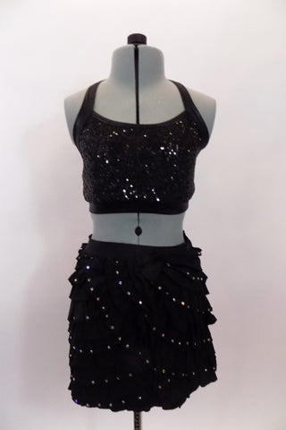 2-piece, costume has sequined black half top with crystals, that accompanies a black ruffle stretch skirt with multiple layers of small ruffles with crystals. Comes with hair accessory. Front