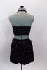2-piece, costume has sequined black half top with crystals, that accompanies a black ruffle stretch skirt with multiple layers of small ruffles with crystals. Comes with hair accessory. Back