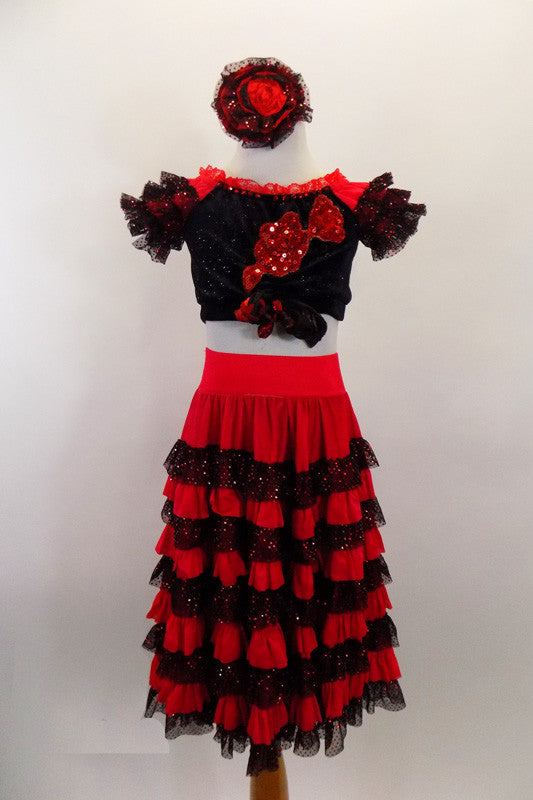 Spanish style 2-piece costume has calf length red & black lace ruffled skirt. Black velvet half top has bow & red sequin applique front & short ruffled sleeves. Comes with matching hair accessory. Front