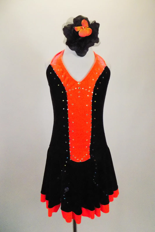 Black & bright orange halter dress has crystal covered orange front center & skirt ruffle. The back is open & ties at both center & neck. Comes with hair accessory. Front