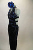 Black velvet based unitard has halter front with open center & leg design. Top has swirls of blue-silver lined with crystals.  2 black bands wrap around back. Comes with large blue floral accessory. Left side