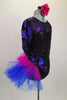 Black sequined leotard with sweetheart neckline has sheer black mesh upper with long sleeves covered in blue & magenta sequined swirls & large right hip pouf. Comes with matching floral hair accessory. Right side