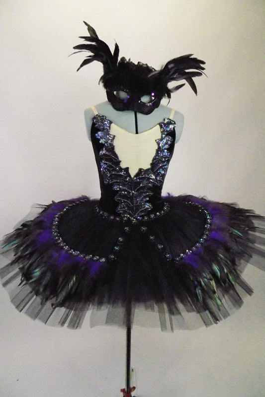 Platter tutu with oblong tail shape. The black base has an overlay of iridescent appliques &hints of green, black & purple feathers. Comes with feathered mask. Front