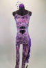 Iridescent purple animal print camisole unitard has chiffon ruffles down the left leg. Stomach area is open with crystalled band. Comes with hair accessory. Front