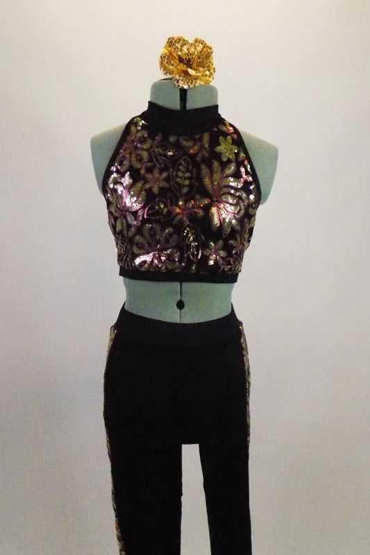Black halter style top has gold sequined floral design with black leggings that have matching sequin fabric down each leg. Comes with matching hair accessory. Front
