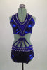2-piece electric blue sequined costume is attached in at the front midriff by a series of straps. The costume is lines entirely with pointy metal studs. Comes with matching hair accessory. Front