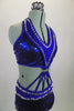 2-piece electric blue sequined costume is attached in at the front midriff by a series of straps. The costume is lines entirely with pointy metal studs. Comes with matching hair accessory. Side zoomed