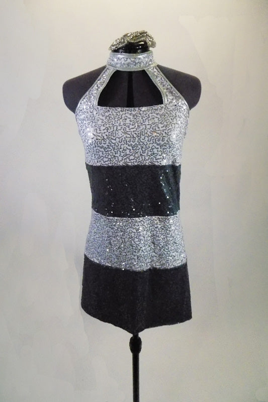 Sequined tunic dress has wide stripes of silver and charcoal with high neck open chest halter style cut. comes with matching hair accessory. Front