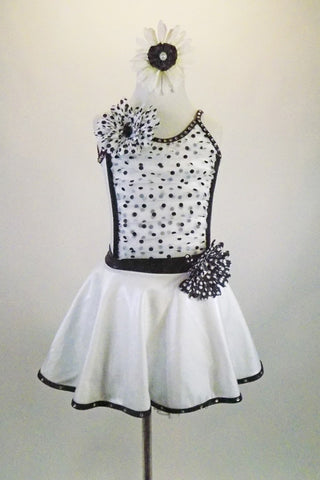 Shiny white lycra dress has low scoop back & black banding covered with crystals. Front torso is sheer ruched white & black polka dots. Has dotted daisy accents. Front
