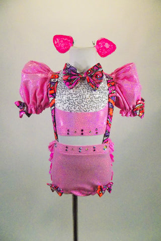Pink piggy-themed 2-piece costume has pouf sleeved half top with keyhole back & laced back. Matching short has back ruffles, curly tail & attached suspenders.  Comes with clip-on ears. Front