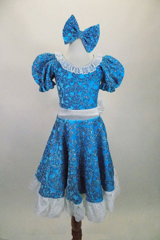 Blue brocade motif glitter velvet 2-piece costume has pouf sleeved leotard with lace collar. The matching knee-length skirt has lace trim & waistband with bow. Comes with matching hair bow. Front