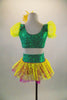 2-piece pink & green costume has bright yellow polka dot layered back bustle & pouf sleeves. Waistband has bright yellow lace up ribbon. Has daisy hair clip. Back