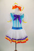 Doll themed ballet dress with blue glitter velvet bodice has blue ribbon accent, sheer white skirt with lace trim & pouf sleeves. Has wind-up plush key at back. Comes with matching hair bow. Front